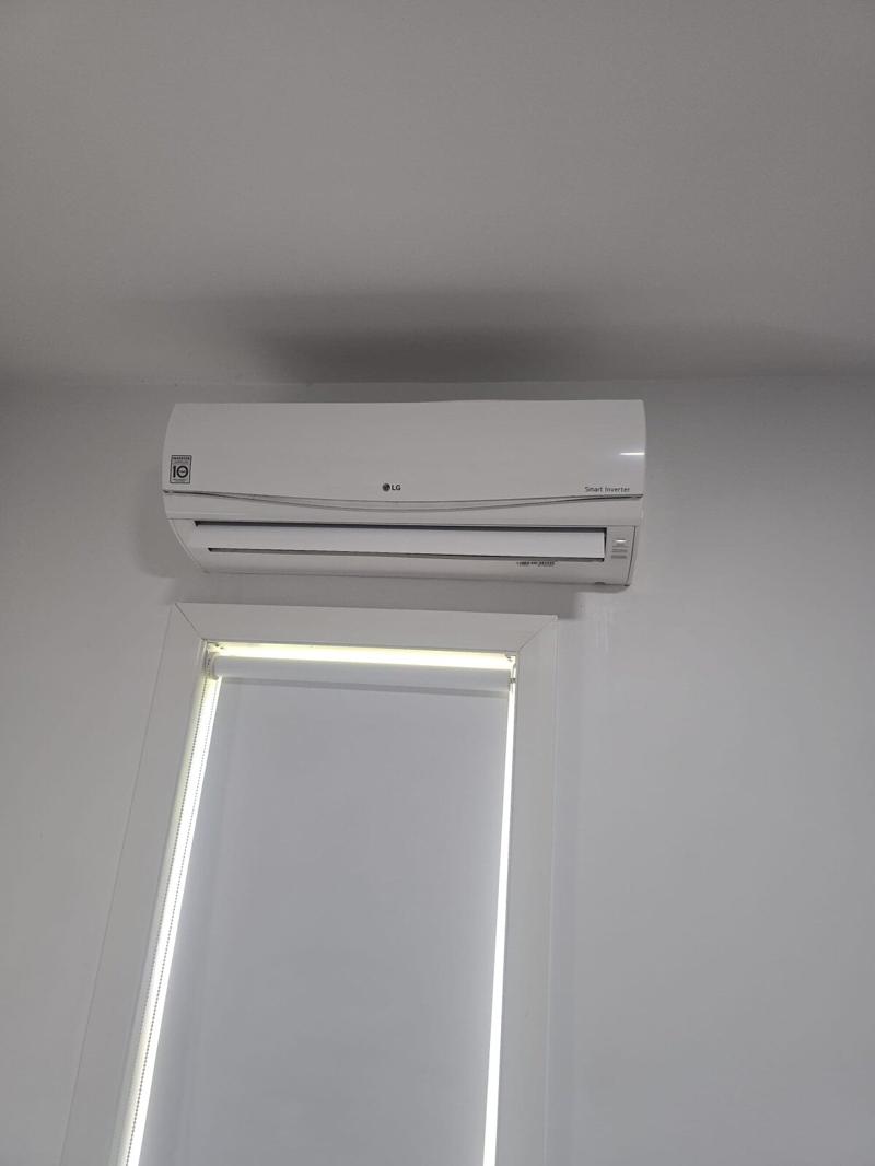 Split system head unit installed on a bedroom wall clear of the window frame