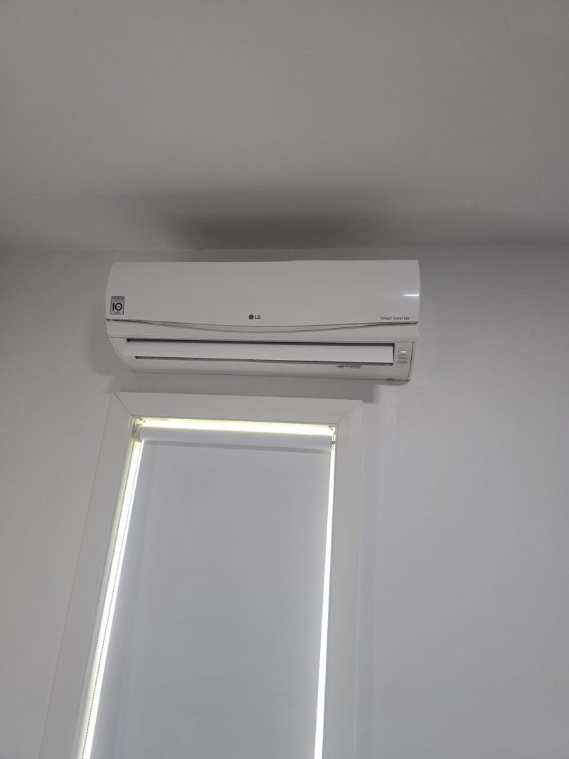Split system head unit installed on a bedroom wall clear of the window frame